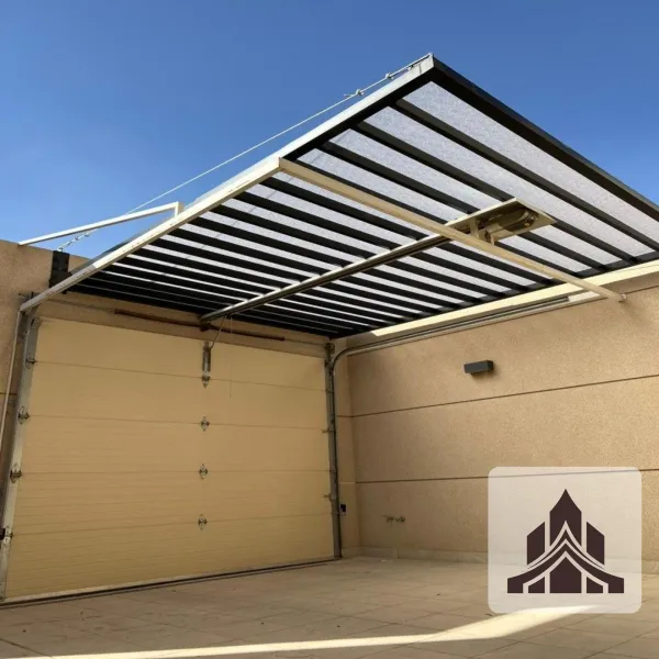 مظلة أمام مدخل منزل في مكة بتصميم عملي يحمي الممر من الشمس والمطر، مع خامة عالية الجودة واستخدام أعمدة قوية لضمان الثبات والمتانة.